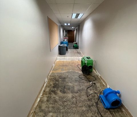 A long hallway with a vacuum cleaner on the floor.