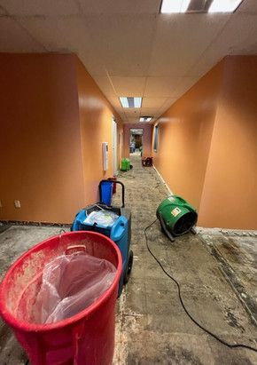 A long hallway with a trash can in the middle of it.