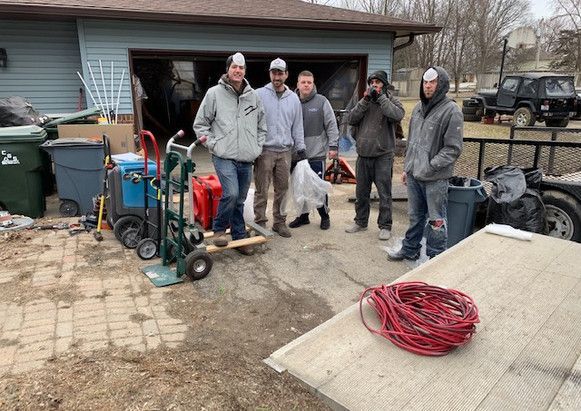 A group of men are standing in front of a garage.