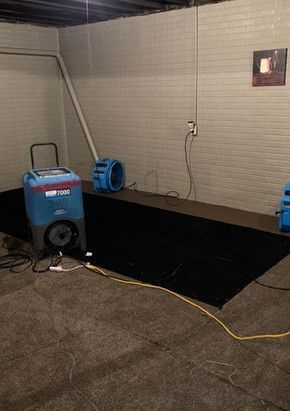 A room with a vacuum cleaner and a fan in it.