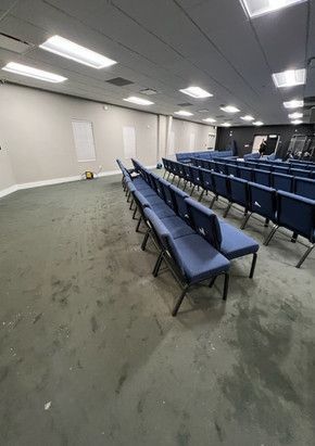 A large room with rows of blue chairs in it.