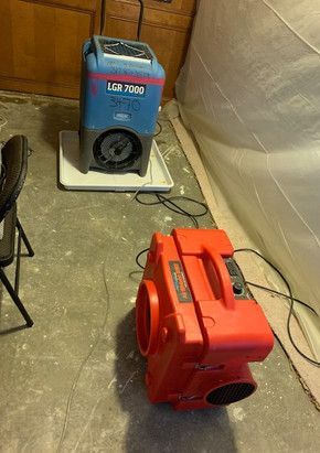 Two air conditioners are sitting next to each other in a room.