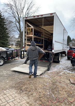 A man is standing in front of a moving truck.