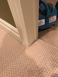 A vacuum cleaner is sitting on the floor next to a door.