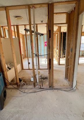 A room with a lot of wooden frames and wires hanging from the ceiling.