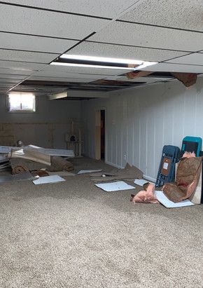 A room with a carpeted floor and a ceiling that is missing.