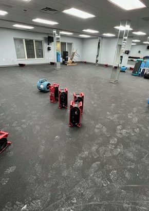 A large empty gym with a lot of fans on the floor.