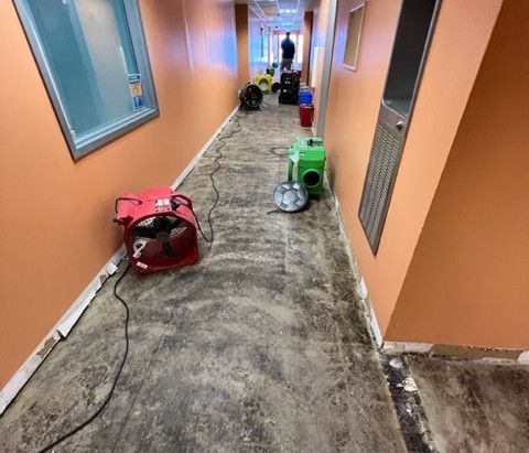 A long hallway with a red fan on the floor.