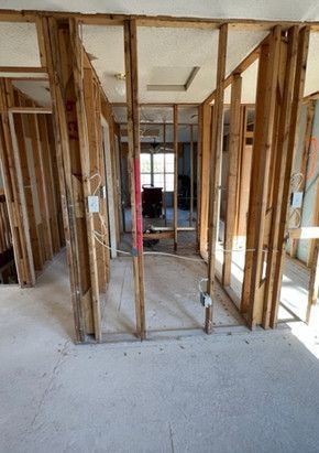 A room with wooden walls and a carpeted floor in a house under construction.