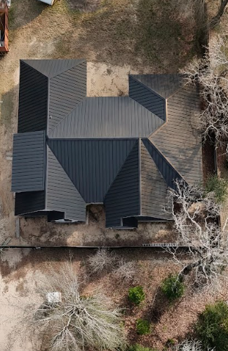 Overhead view of a house with a complex, geometric roof in shades of black, gray, and brown.