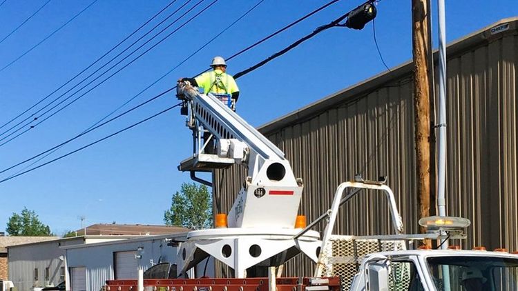 construction in bucket truck getting elevated towards power lines