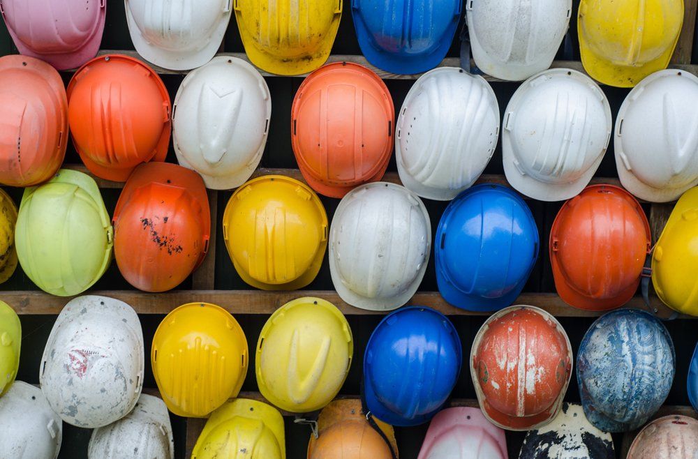 rows of hardhats of different colors
