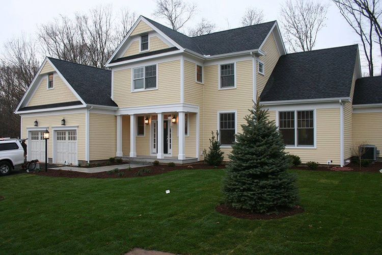 A large yellow house with a black roof