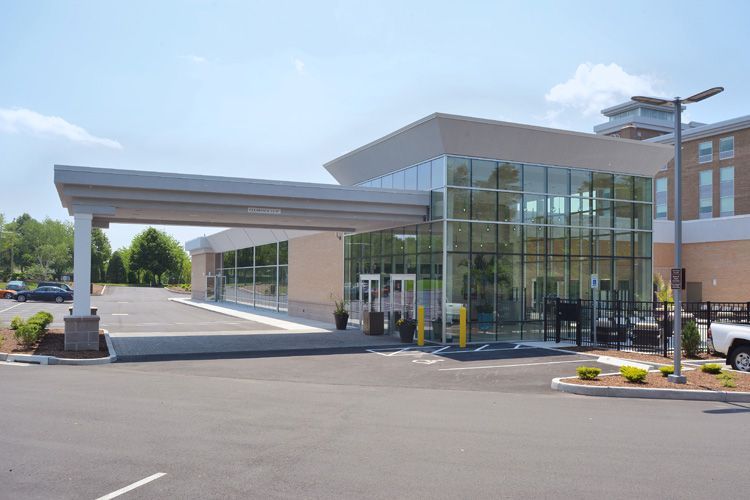 A large building with a lot of windows and a car parked in front of it.