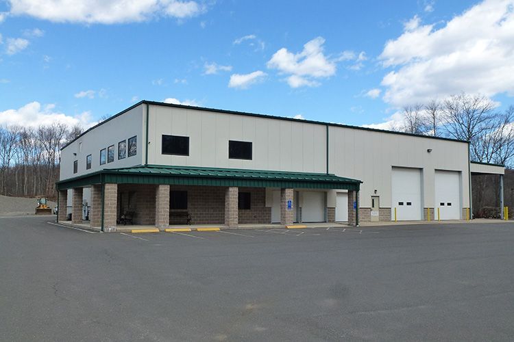 A large white building with a green roof and white doors