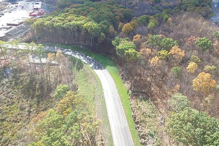 An aerial view of a road going through a forest