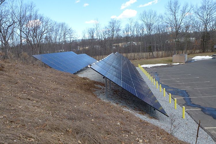 A row of solar panels sitting on top of a hill