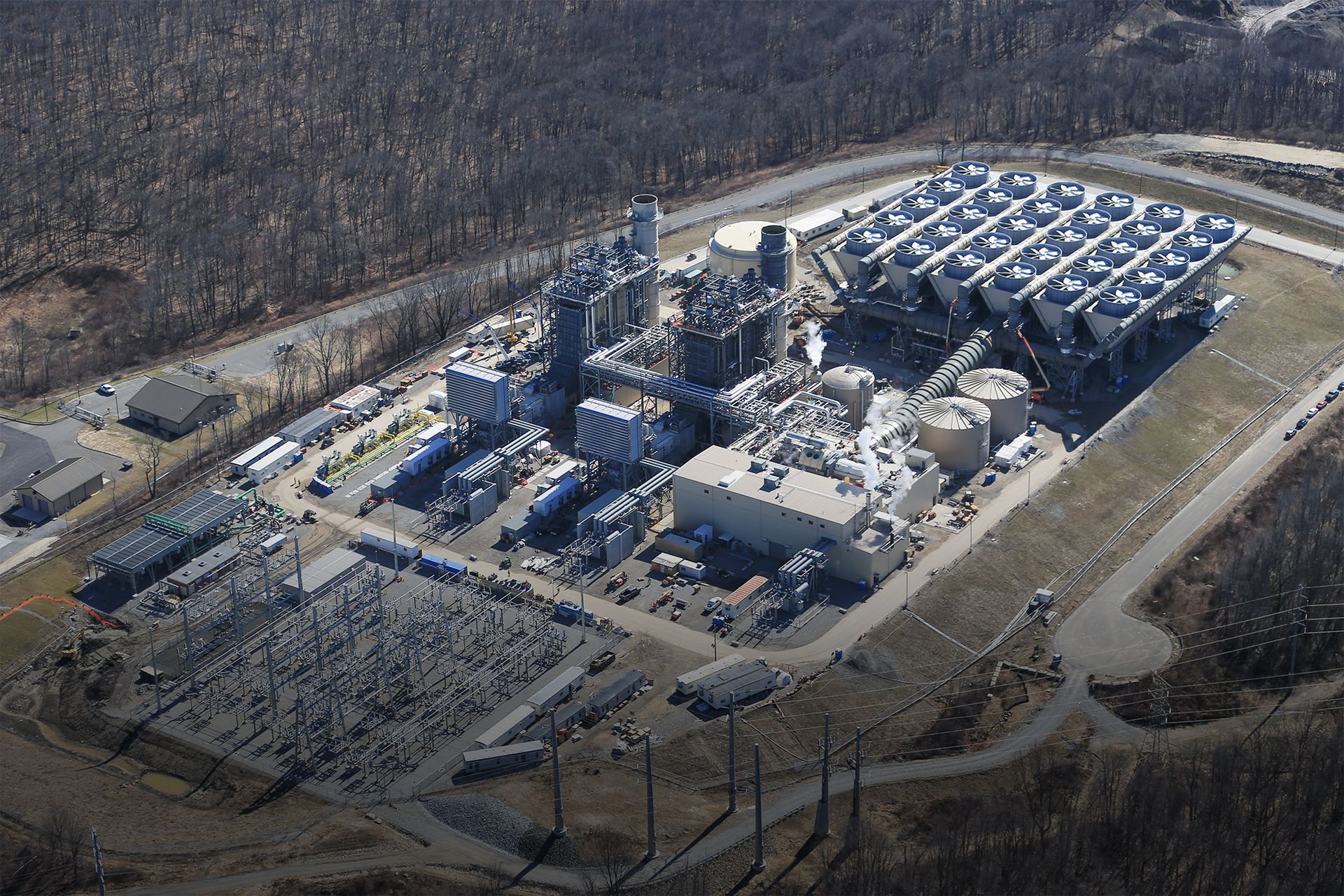 An aerial view of a power plant surrounded by trees