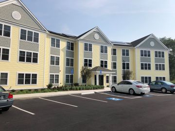 A large yellow building with cars parked in front of it.