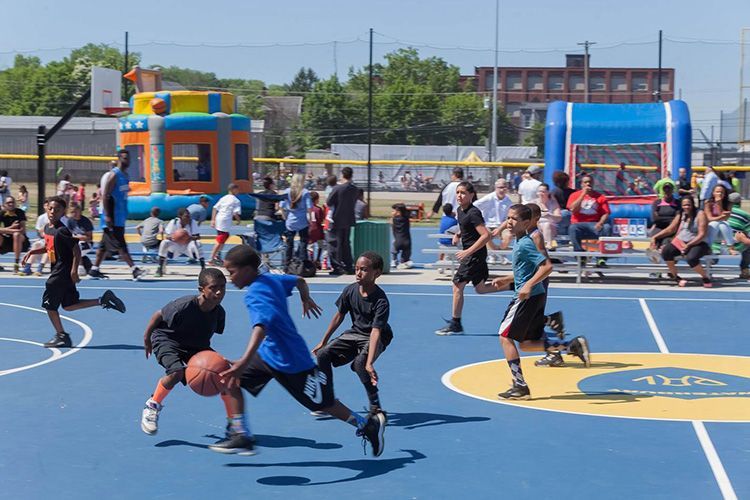 A group of young boys are playing basketball on a court.