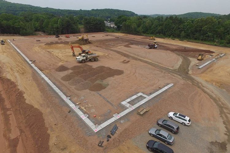 An aerial view of a construction site with cars parked in front of it.