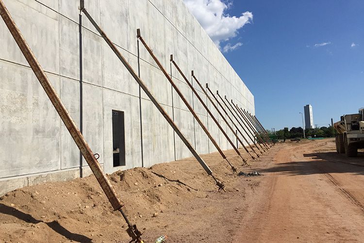 A truck is parked in front of a building under construction.