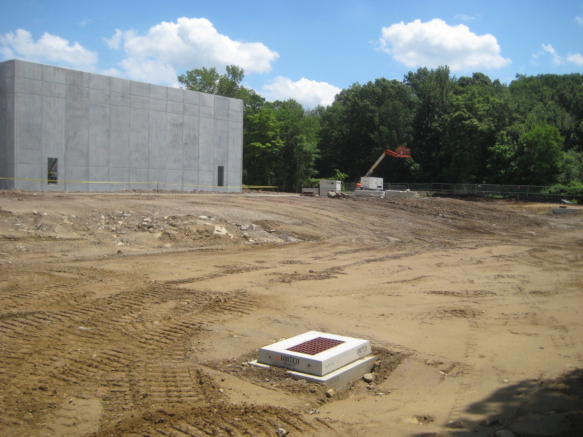 A large concrete building is being built in the middle of a dirt field