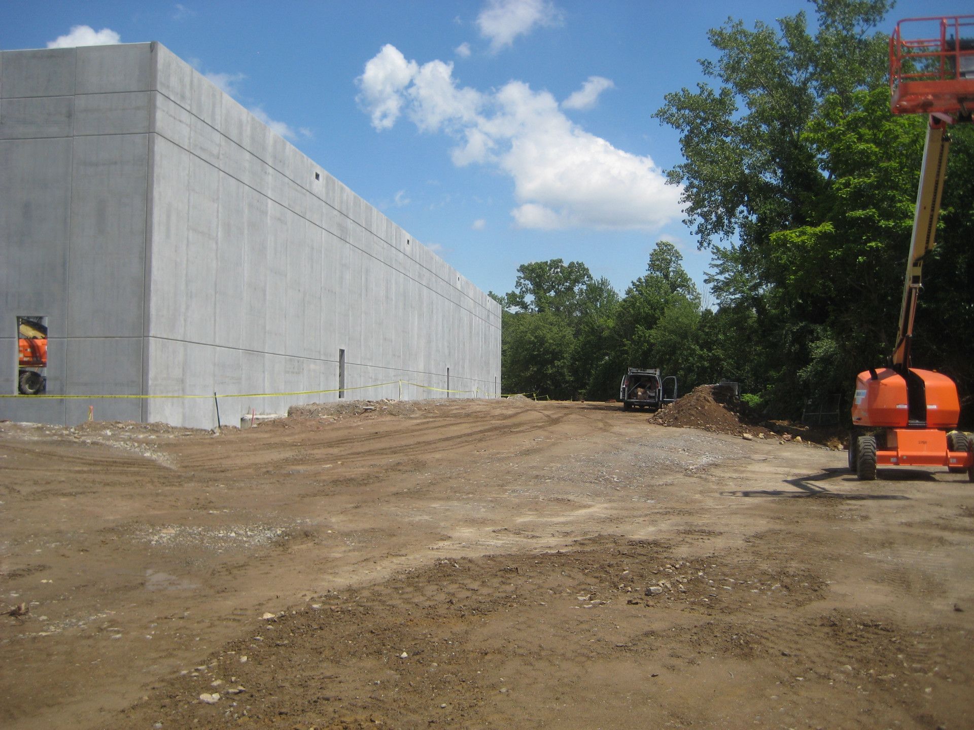 A construction site with a large concrete building in the background