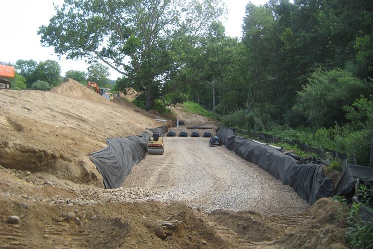 A construction site with a lot of dirt and trees in the background