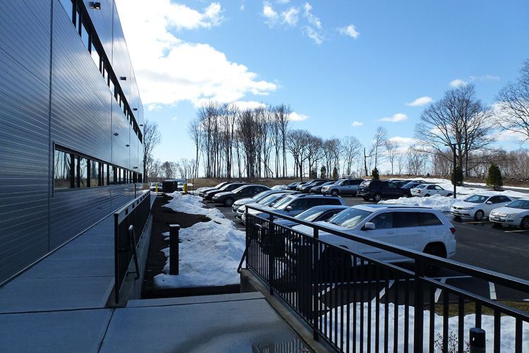A parking lot with cars parked in front of a building.