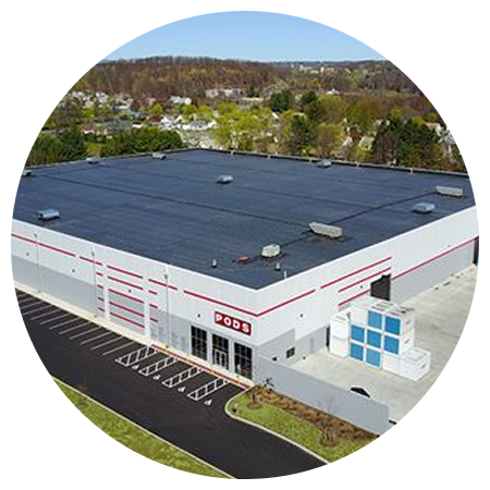 An aerial view of a large white building with a black roof.