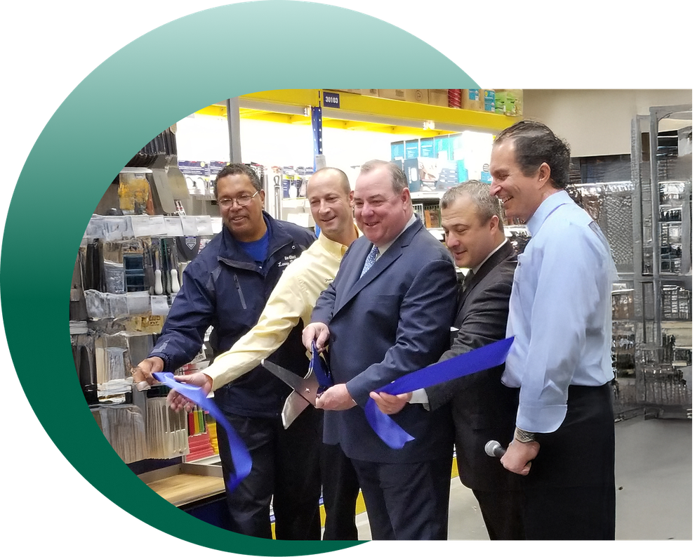 A group of men are cutting a blue ribbon in a store