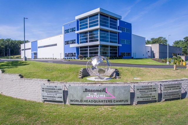 A large blue and white building with a sign in front of it.