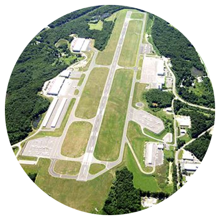 An aerial view of an airport surrounded by trees and grass
