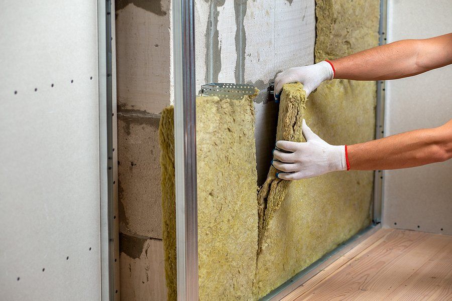 worker installing insulation in the wall