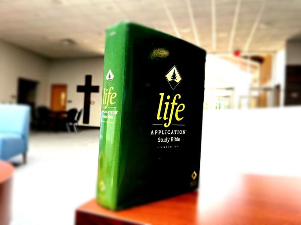A green bible with the word life on it