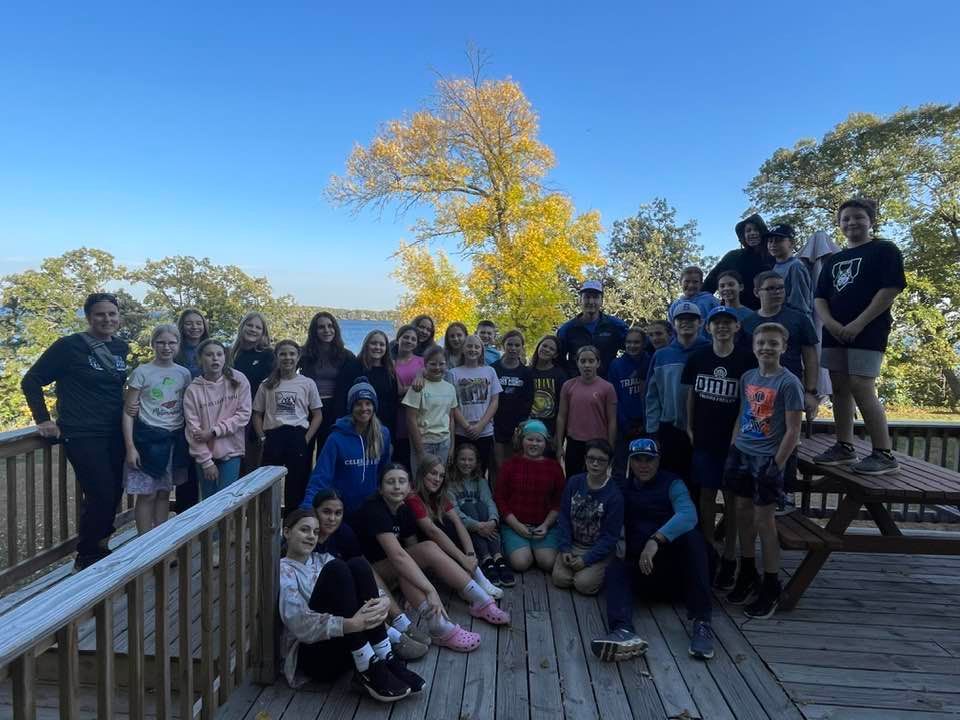A group of children are posing for a picture on a deck.