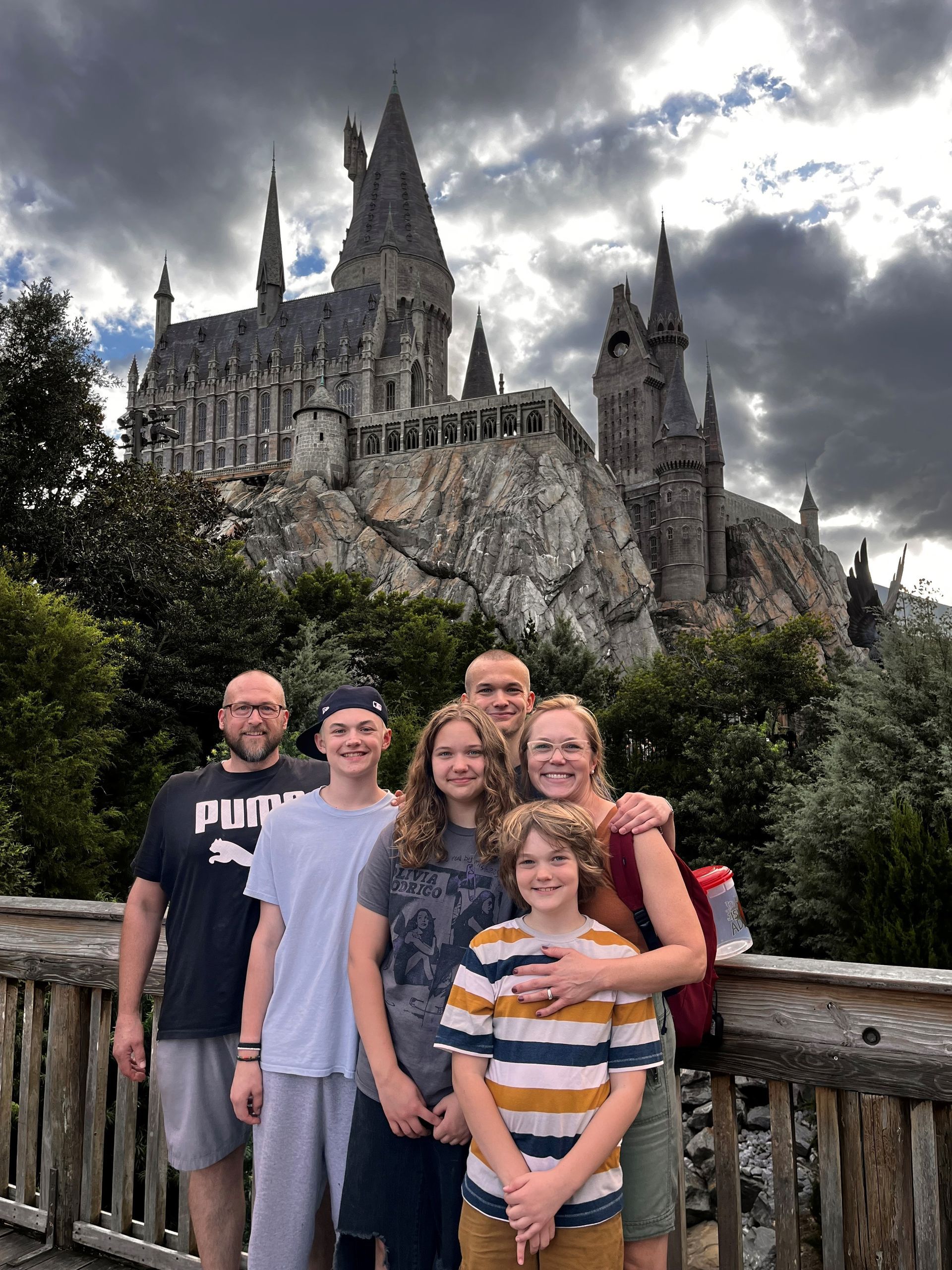 A family is posing for a picture in front of a castle.