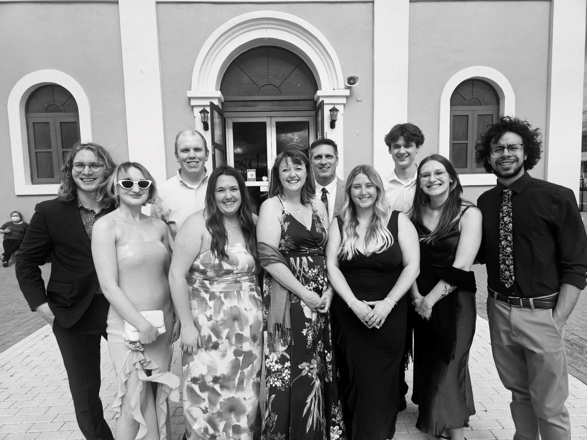 A group of people are posing for a picture in front of a building.