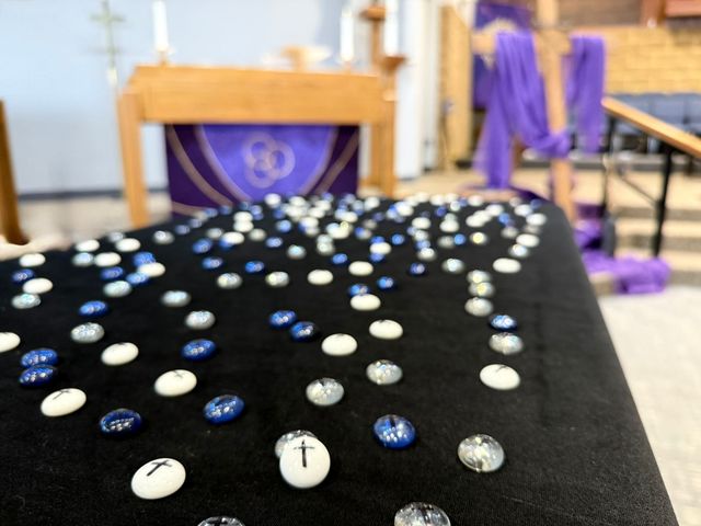 A man is kneeling down next to a little girl in a church.