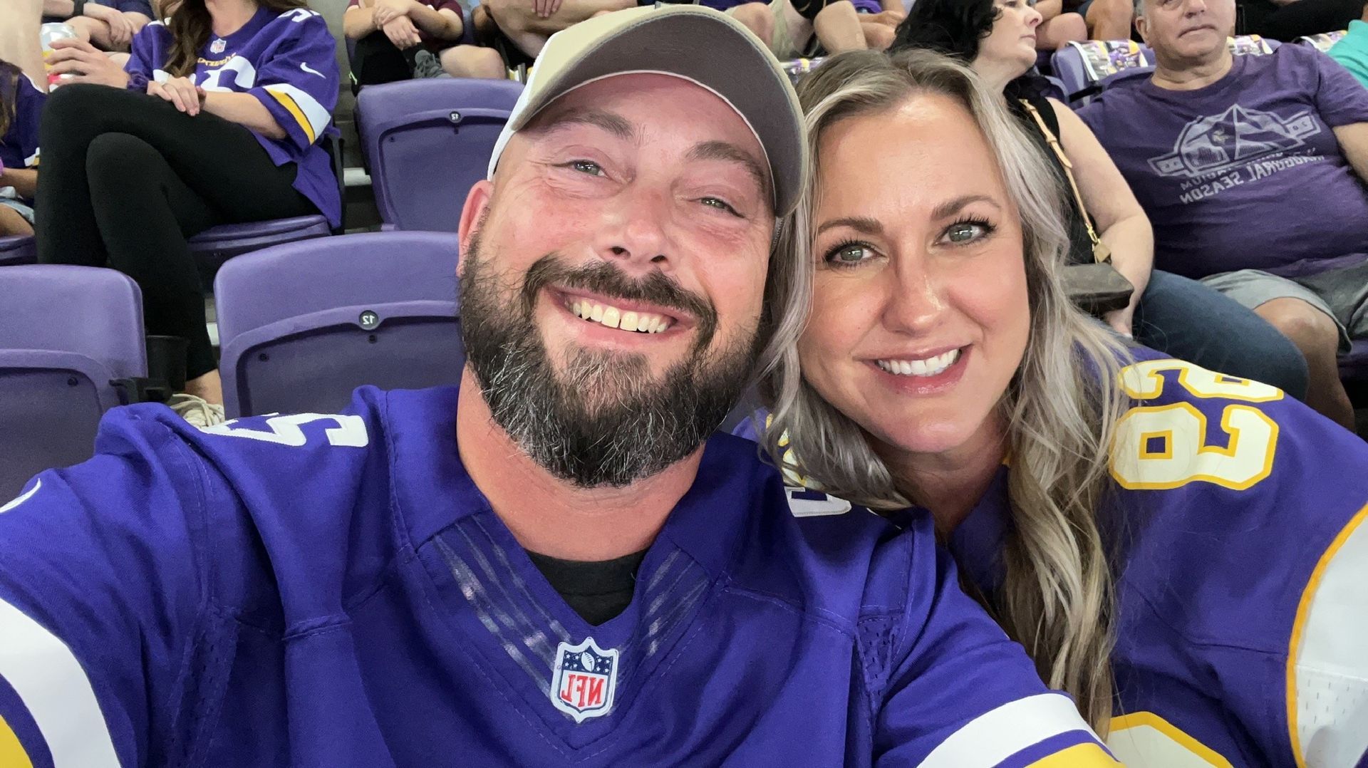 A man and a woman are taking a selfie in a stadium.