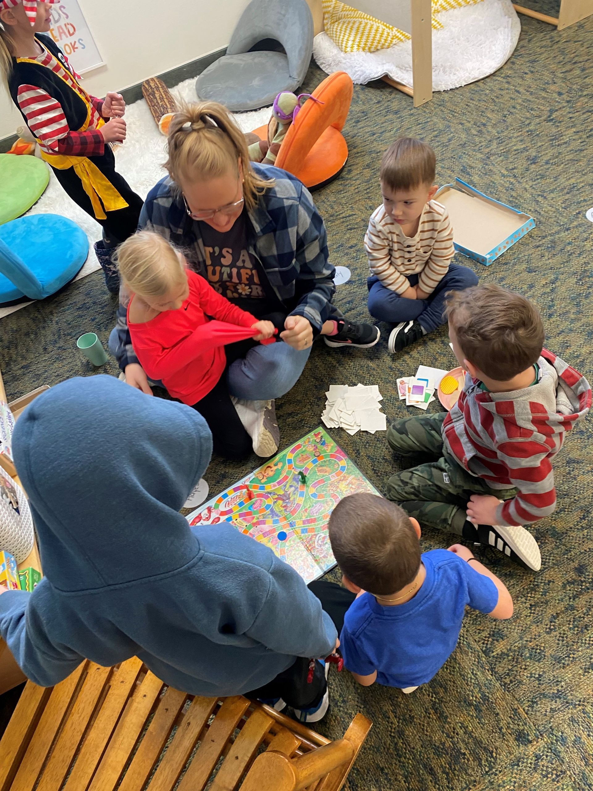 A group of children are sitting on the floor in a room.