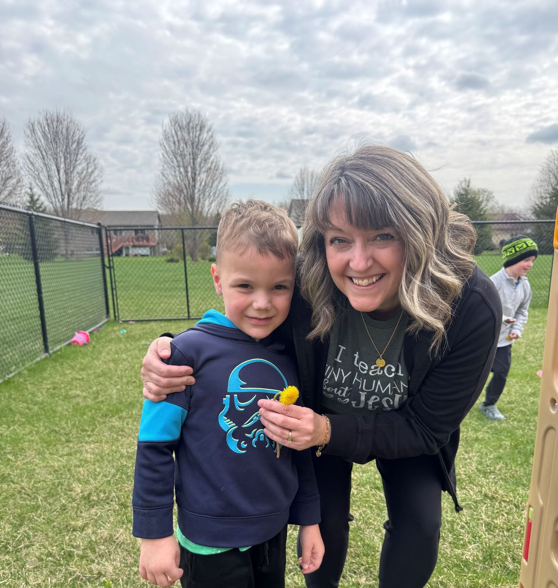 A woman and a boy are posing for a picture in a field