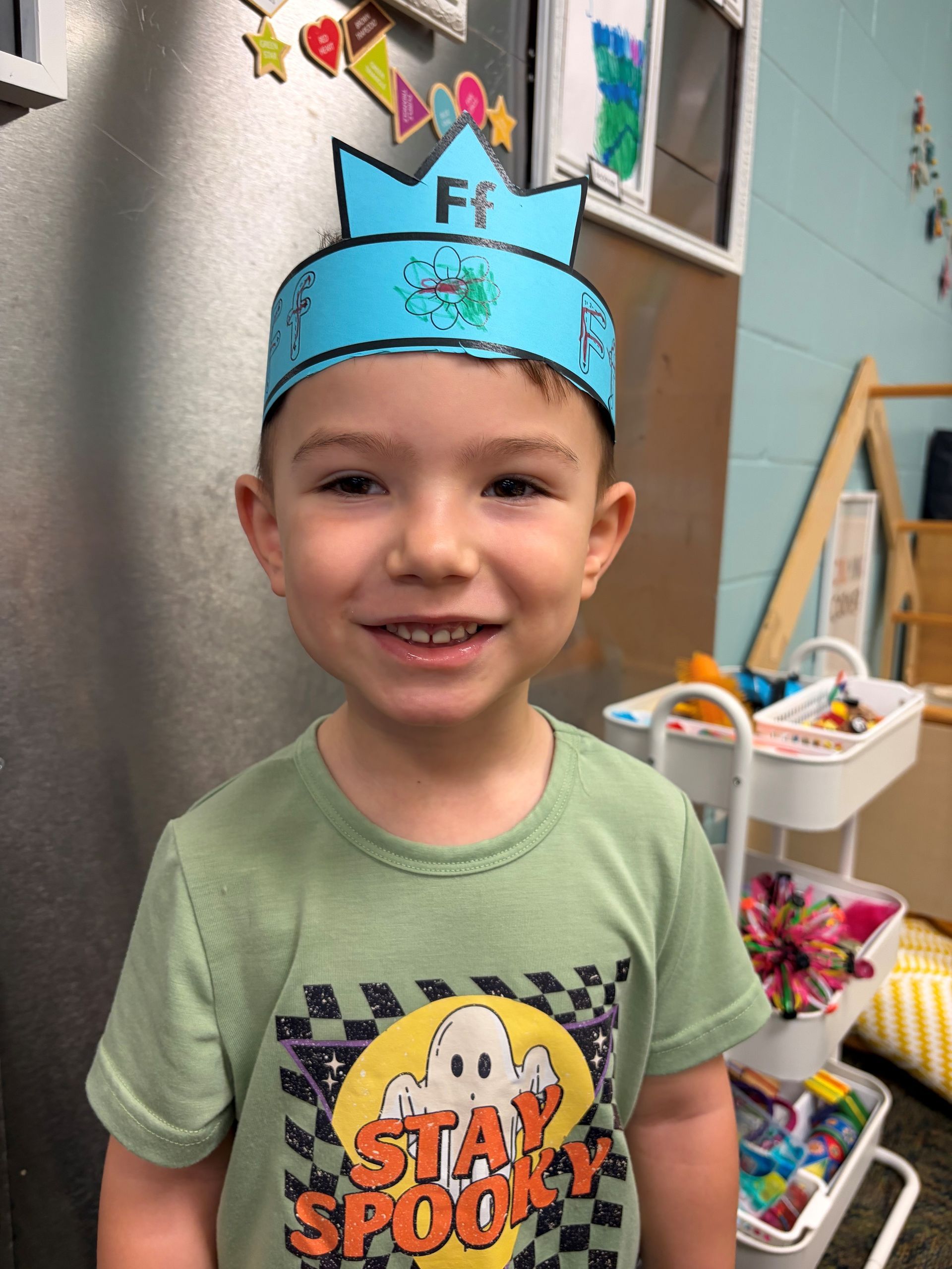 A young boy with his hands covered in blue paint
