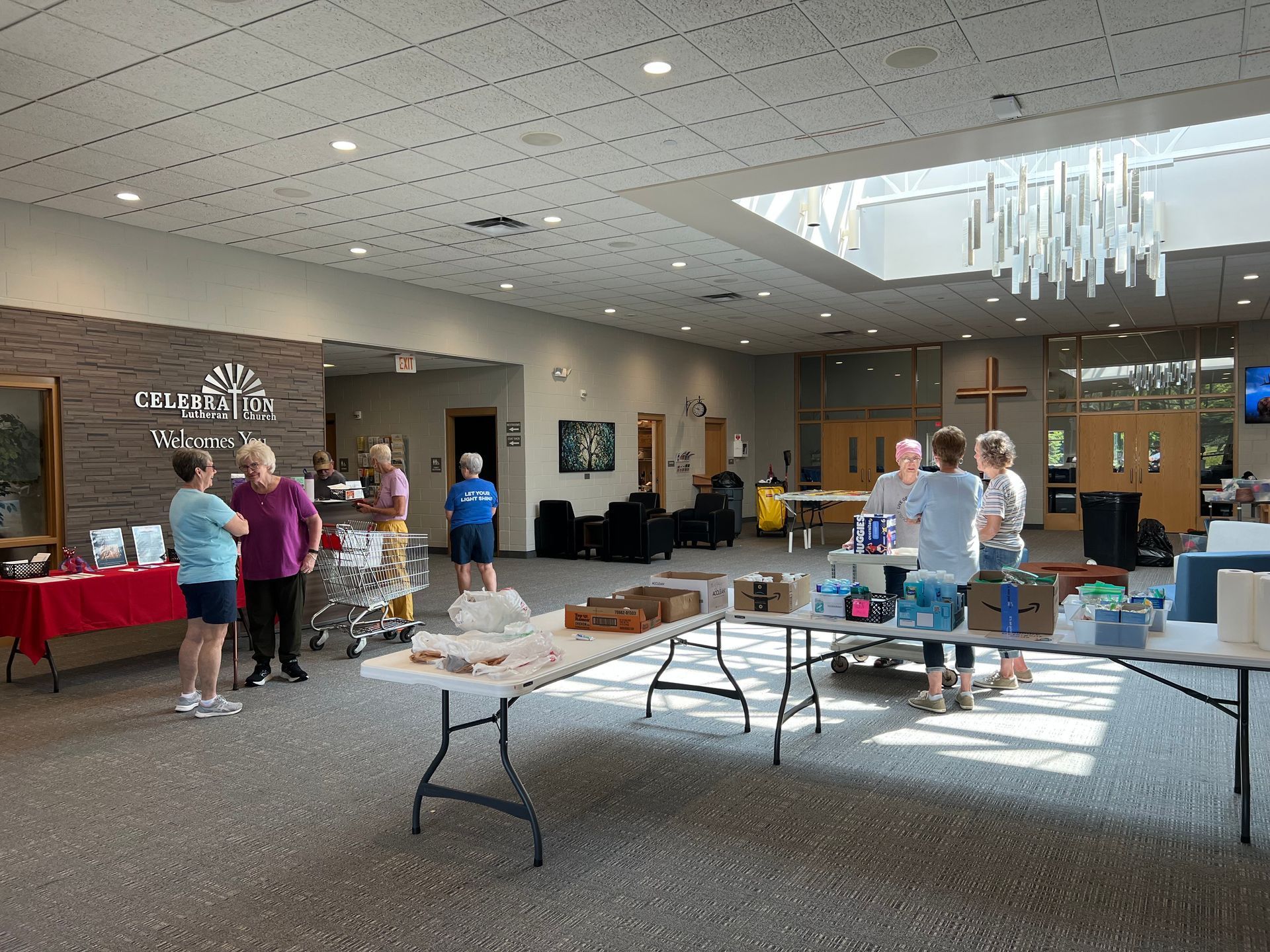 A group of people are standing around tables in a large room.