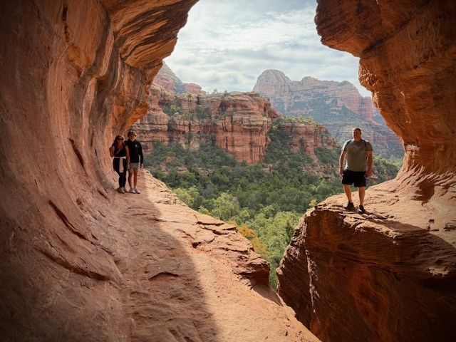 A man and a woman are standing on the edge of a cliff.