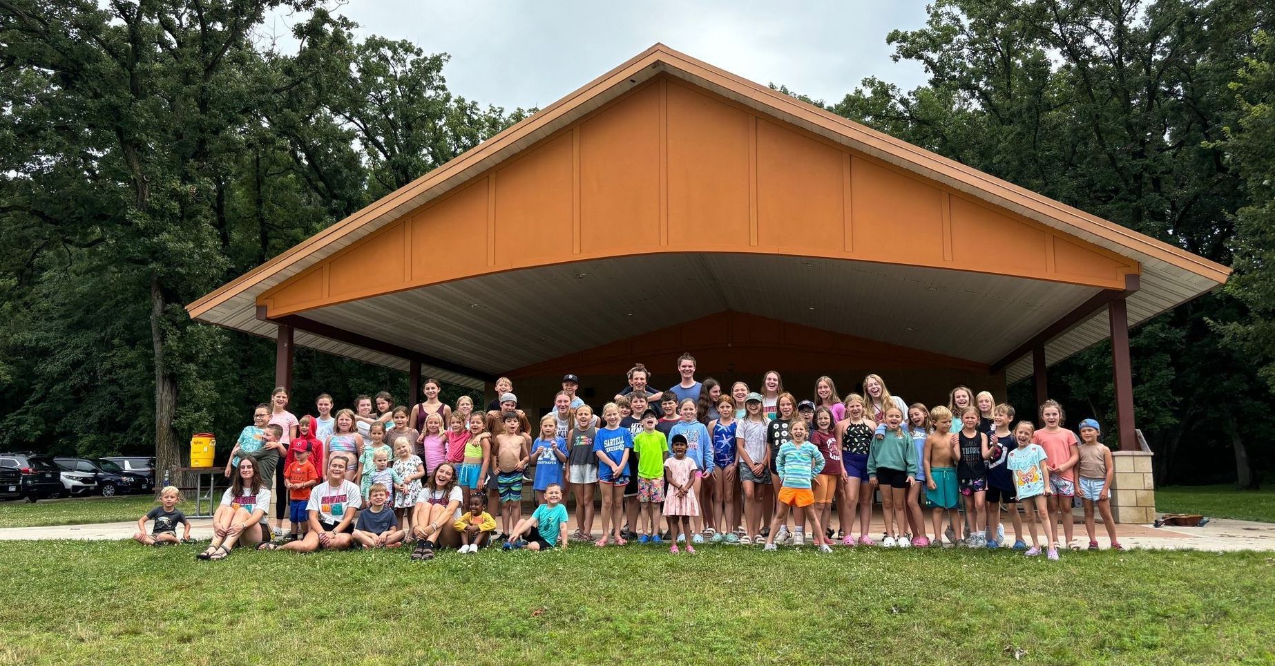 A large group of people are posing for a picture in front of a pavilion.