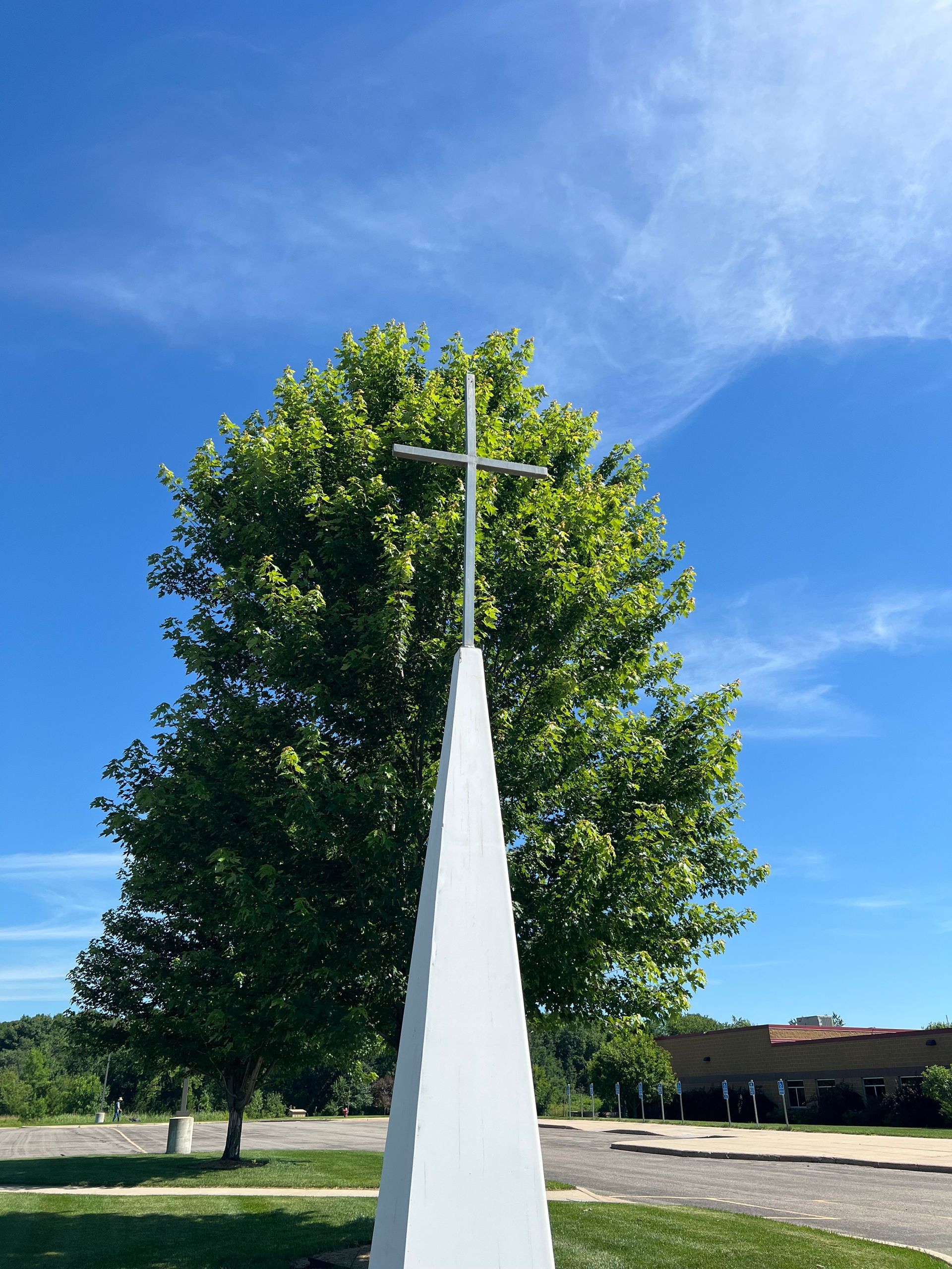 A white obelisk with a cross on top of it