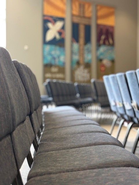A row of chairs are lined up in a waiting room.