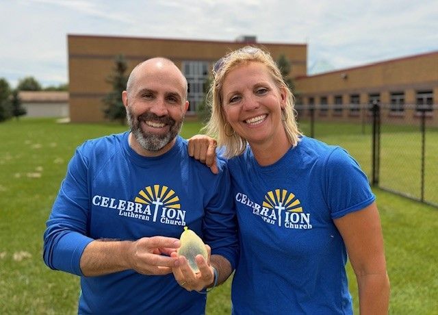 A man and a woman are standing next to each other wearing blue shirts that say celebration.